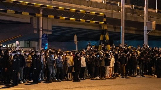 Onlookers stand by the road during the protest in Beijing, on November 28. The normally supportive head of the World Health Organization has called “Zero COVID” unsustainable. Beijing dismissed his remarks as irresponsible, but public acceptance of the restrictions has worn thin, AP reported.(Bloomberg)