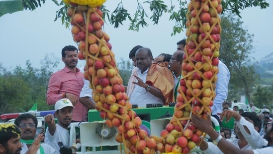 JD(S) workers welcome Kumaraswamy with fruit garlands during his road show in Karnataka JD(S) workers welcome Kumaraswamy with fruit garlands during his road show in Karnataka