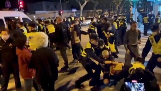 Police officers detain people during a protest against coronavirus disease (Covid-19) curbs at the site of a candlelight vigil for victims of the Urumqi fire, in Shanghai, China in this screengrab obtained from a video released on November 27, 2022. (via REUTERS)