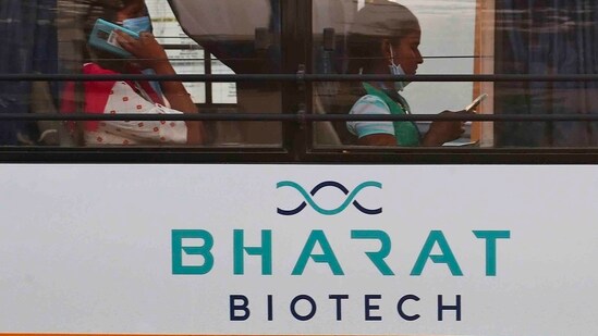 An employee of Bharat Biotech speaks on a mobile phone inside a bus (AP Photo)