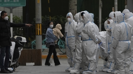 Workers in protective gear gather for their duties in Beijing.(AP)