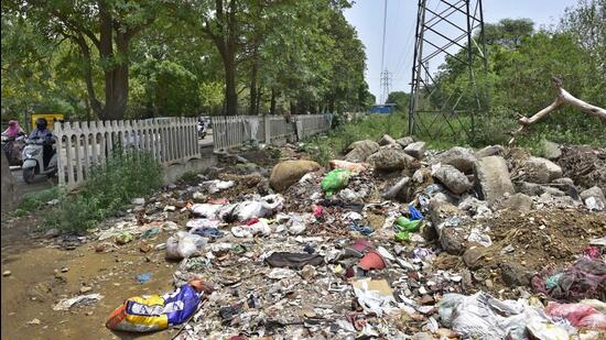 Construction waste dumped in Model Town area near cremation ground in Ludhiana. After finding garbage beneath the site, the authorities will now have to change the design of the project, which will further lead to delay in its completion. (HT PHOTO)