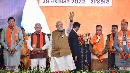 Prime Minister Narendra Modi waves at supporters during a public meeting ahead of Gujarat assembly elections, in Rajkot on Monday. (PTI)