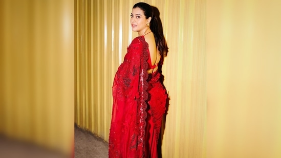 Kajol styled her saree with a plunging, backless neckline blouse featuring netted sleeves.(Instagram/@kajol)