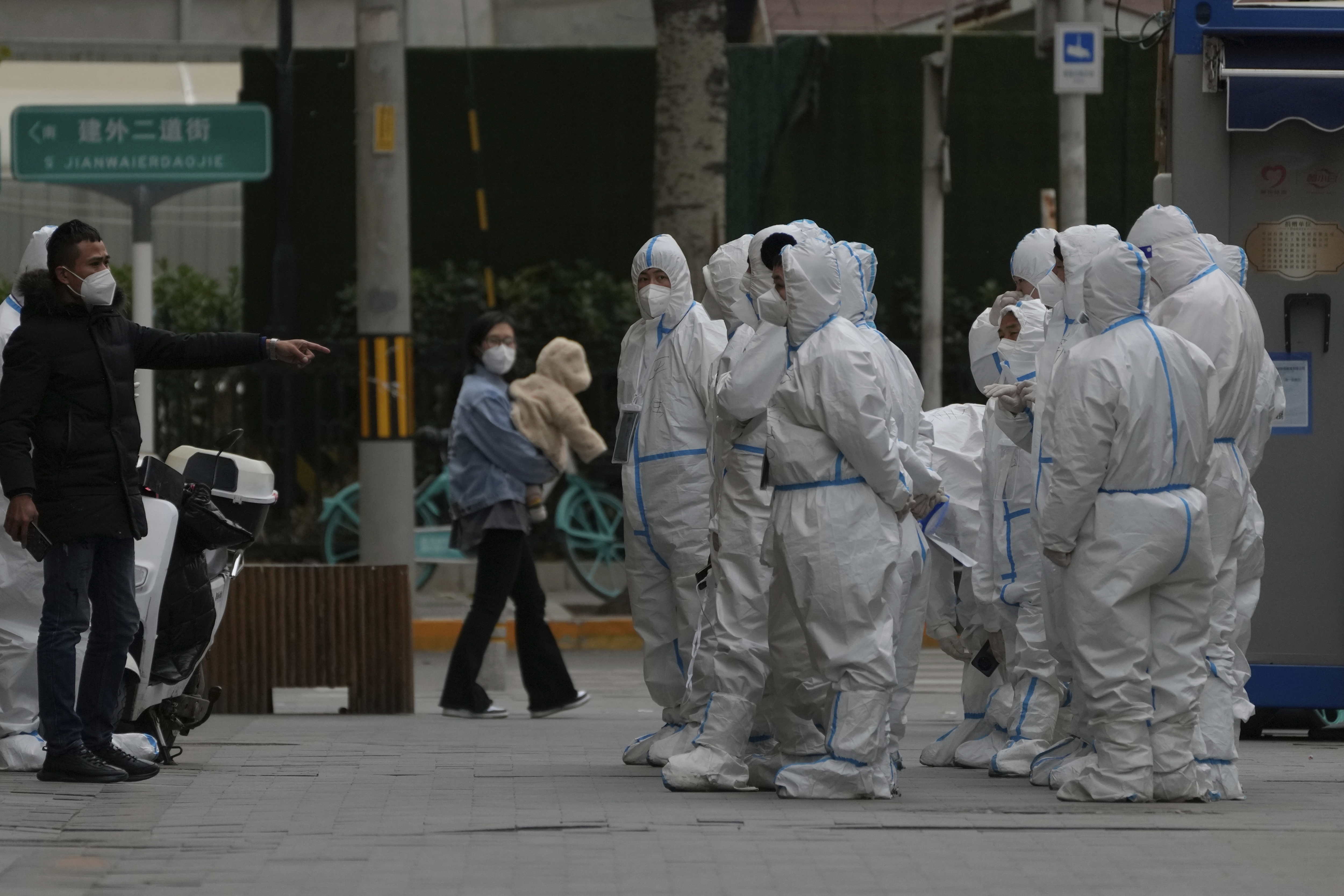 Workers in protective gear gather for their duties in Beijing. (AP) Workers in protective gear gather for their duties in Beijing. (AP)