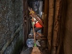 A Solid Waste Management (SWM) team worker of the D ward seen at work during the special cleanliness drive in Mumbai, on November 25. The drive is being conducted in lanes between cessed buildings. Cessed buildings are old or dilapidated mainly located in the city division of the BMC.(Satish Bate / HT Photo)