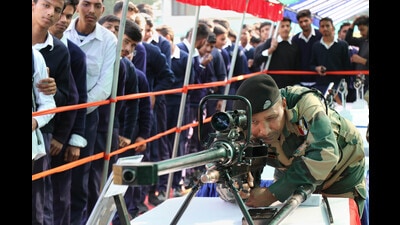 A Border Security Force (BSF) personnel demonstrating a weapon to students at a weapons display in Jammu on Tuesday. (PTI)