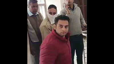 The accused ASI (face covered) in vigilance custody.