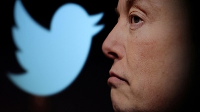 Twitter logo and a photo of Elon Musk are displayed through magnifier in this illustration. (Reuters)