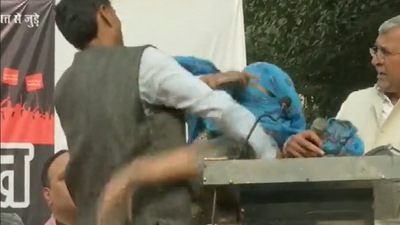 A woman hits a man with slippers on the stage of 'Beti Bachao' mahapanchayat by Hindu Ekta Manch in Delhi's Chattarpur area. (ANI) A woman hits a man with slippers on the stage of 'Beti Bachao' mahapanchayat by Hindu Ekta Manch in Delhi's Chattarpur area. (ANI)