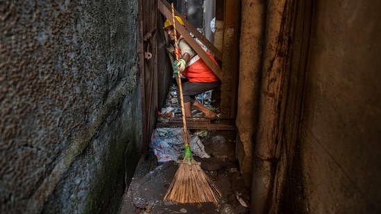 A Solid Waste Management (SWM) team worker of the D ward seen at work during the special cleanliness drive in Mumbai, on November 25. The drive is being conducted in lanes between cessed buildings. Cessed buildings are old or dilapidated mainly located in the city division of the BMC.(Satish Bate / HT Photo)