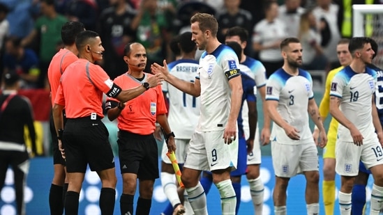 England's forward Harry Kane (R) shakes hands with referees at the end of the Qatar 2022 World Cup Group B football match