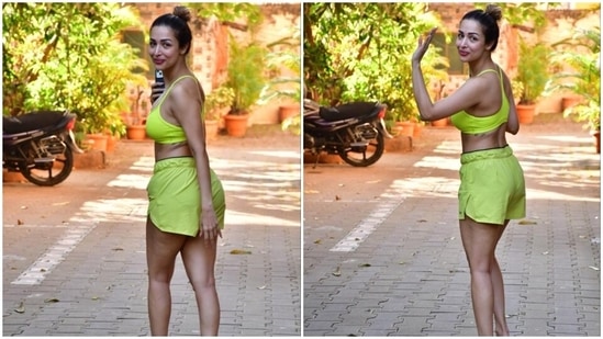 For her workout today, Malaika chose a neon green sports bra and matching shorts set styled with minimum aesthetic. Before heading for the exercise session, Malaika posed, smiled and waved to the paparazzi.(HT Photo/Varinder Chawla)