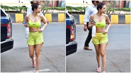 Malaika's neon green sports bra features barely-there halter straps, racerback details, a fitted bust, a plunging U neckline flaunting her décolletage, and a cropped hemline baring the star's toned midriff.(HT Photo/Varinder Chawla)