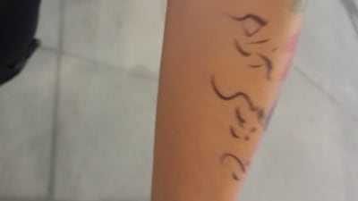 Nada, who lives in California but was born in Iran, shows her tattoo in support of women's rights, at Al Thumama Stadium on Tuesday. (Dhiman Sarkar/HT) Nada, who lives in California but was born in Iran, shows her tattoo in support of women's rights, at Al Thumama Stadium on Tuesday. (Dhiman Sarkar/HT)