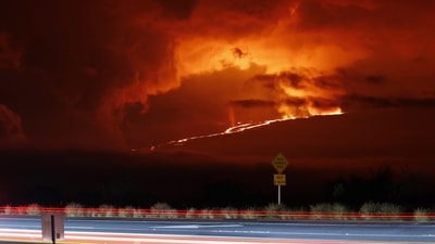 Vehicles could be seen driving down the Saddle Road as Mauna Loa erupted in the distance, leaving a breathtaking view of a rare historic event. "The eruption of Mauna Loa has migrated from the summit to the Northeast Rift Zone where fissures are feeding several lava flows," the USGS said adding that there was currently no threat to people living below the eruption zone, but warned that the volcano was volatile. (Marco Garcia / AP) Vehicles could be seen driving down the Saddle Road as Mauna Loa erupted in the distance, leaving a breathtaking view of a rare historic event. "The eruption of Mauna Loa has migrated from the summit to the Northeast Rift Zone where fissures are feeding several lava flows," the USGS said adding that there was currently no threat to people living below the eruption zone, but warned that the volcano was volatile. (Marco Garcia / AP)