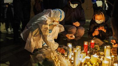 Activists light candles outside the Chinese consulate in Chicago during a rally to support protesters in China on Tuesday. (AP) Activists light candles outside the Chinese consulate in Chicago during a rally to support protesters in China on Tuesday. (AP)