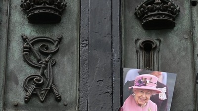 A photograph of late Queen Elizabeth II is pictured on the gate of Buckingham Palace in London. (AFP) A photograph of late Queen Elizabeth II is pictured on the gate of Buckingham Palace in London. (AFP)