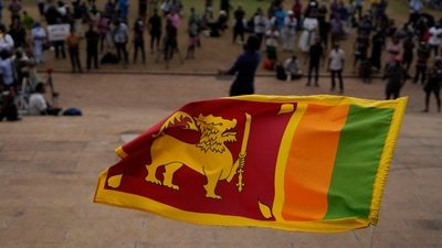 Sri Lanka Economic Crisis: A Sri Lankan flag is waved by a protester. (AP File) Sri Lanka Economic Crisis: A Sri Lankan flag is waved by a protester. (AP File)