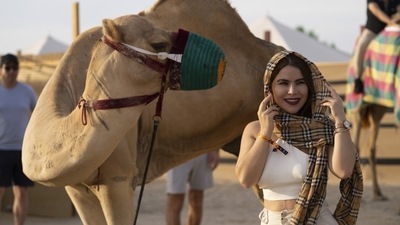A woman stands next to a camel near Sealine Beach in Mesaieed, Qatar. (AP) A woman stands next to a camel near Sealine Beach in Mesaieed, Qatar. (AP)