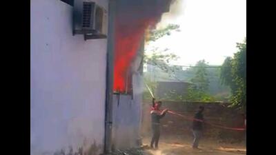 Workers using a hose to douse the flames at the garment unit located in Mangat Colony, Kailash Nagar. (HT File)