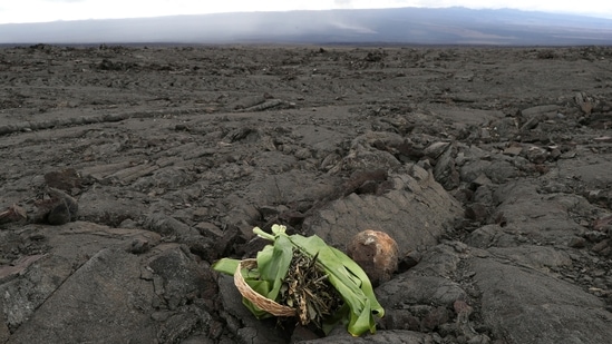 Hawaiian natives left offerings at an old lava field in front of the erupting Mauna Loa, on Tuesday, November 29. Authorities in Hawaii have not issued any evacuation orders, although the summit area and several roads in the region were closed, and two shelters have been opened as a precaution. (Marco Garcia / AP)