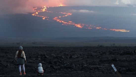 Spectators gathered to watch the lava flow down the mountain from the Mauna Loa eruption, near Hilo, Hawaii, on Tuesday, November 29. Pressure has been building at Mauna Loa for years, according to the United States Geological Survey (USGS), which reported the eruption could be seen from 45 miles (72 kilometers) away.(Marco Garcia / AP)