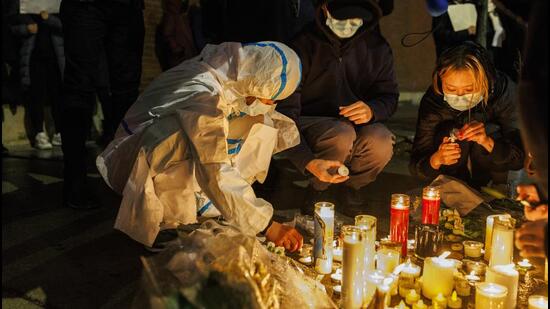 Activists light candles outside the Chinese consulate in Chicago during a rally to support protesters in China on Tuesday. (AP)