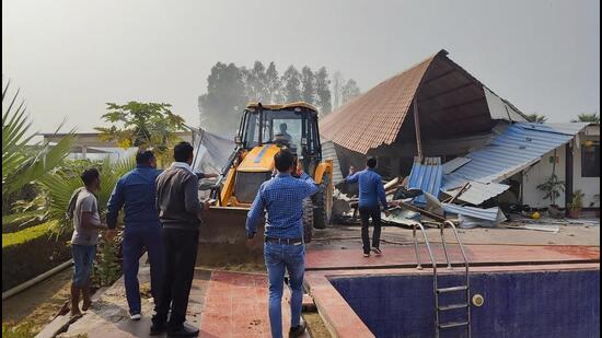 Noida authority officials dismantle an illegal farmhouse at Yamuna Khadar on Wednesday. (PTI)