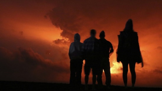 Crowds gathered to watch the lava glow from Hawaii's Mauna Loa volcano, hours after its eruption in Hilo. Experts also cautioned that winds could carry volcanic gas and fine ash downslope. (Caleb Jones / AP)