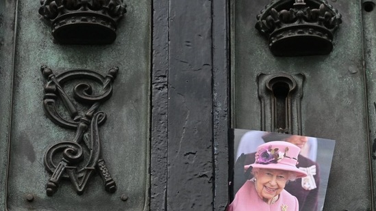 A photograph of late Queen Elizabeth II is pictured on the gate of Buckingham Palace in London.(AFP)