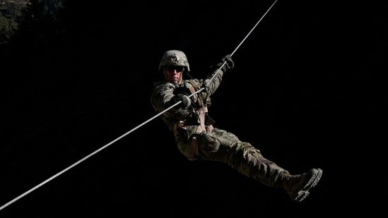 A US army soldier of 2nd Brigade of the 11th Airborne Division slithers down from a zip line during HADR drills in Tapovan, Uttarakhand.(AP)