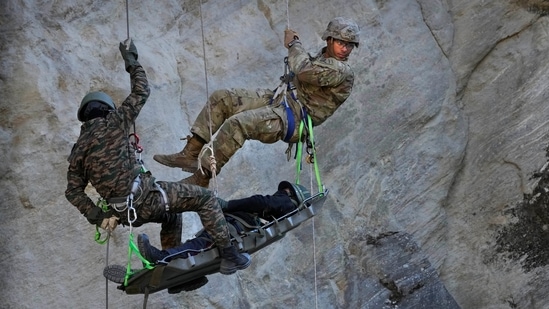 US army soldier with Indian counterpart carries out a mock drill of bringing down an injured villager under HADR operations.(AP)