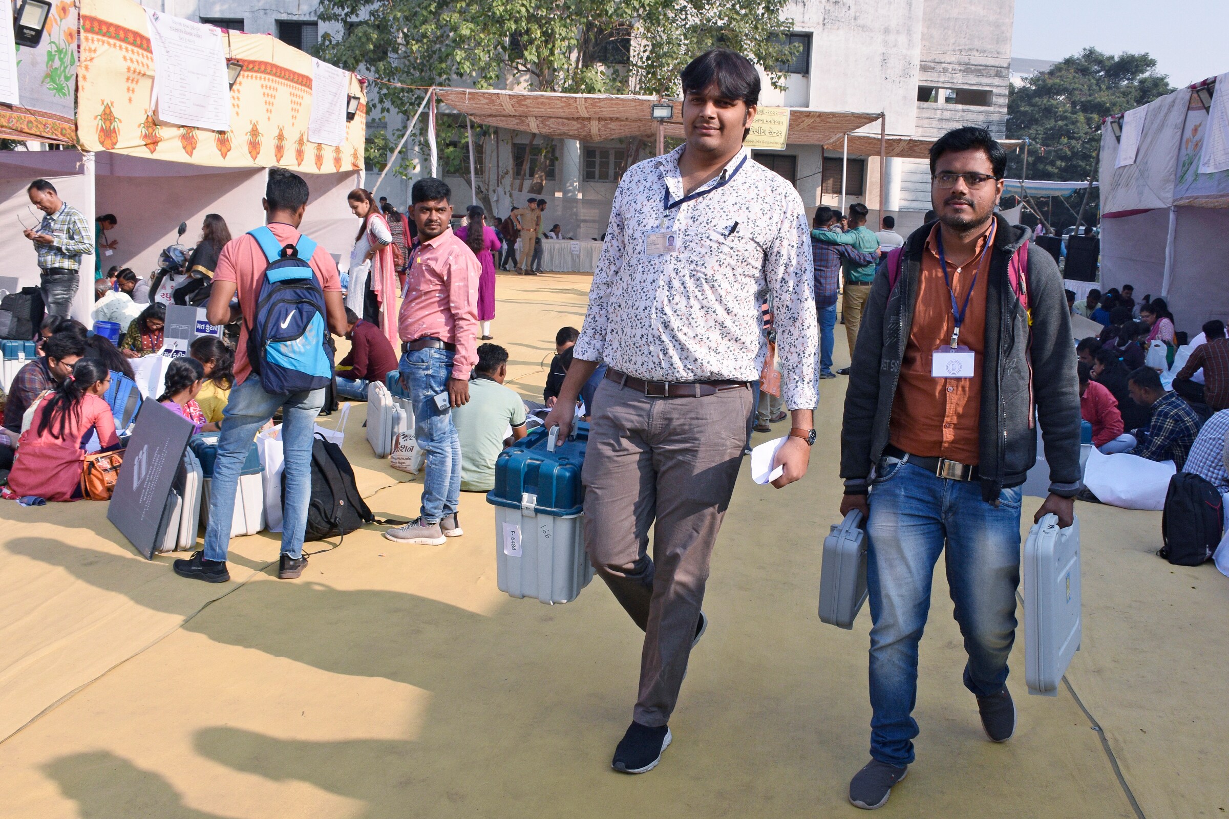 Polling officials carrying Electronic Voting Machines (EVMs) and other polling materials on the way to their respective polling stations on the eve of the first phase of Gujarat Assembly elections, in Surat on Wednesday. (ANI Photo) (Ashok Munjani)