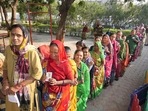 Gujarat Assembly election: People show their identification cards as they wait in a queue to cast their votes during the first phase of Gujarat Assembly elections, in Rajkot.(PTI)