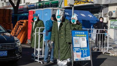 Workers in protective gear at an entrance gate to a neighbourhood placed under lockdown due to Covid in Beijing, China, on Thursday. (Bloomberg) Workers in protective gear at an entrance gate to a neighbourhood placed under lockdown due to Covid in Beijing, China, on Thursday. (Bloomberg)