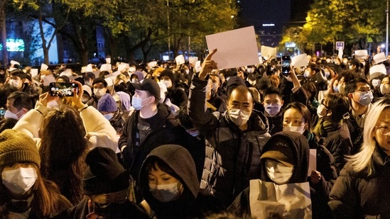 People hold white sheets of paper in protest of Covid-19 restrictions, after a vigil for the victims of a fire in Urumqi, as outbreaks of the coronavirus disease continue in Beijing, China. (Reuters)