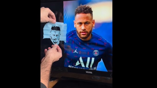 The image, taken from the Instagram video, shows the artist in the process of making Neymar’s portrait using a face mask.(Instagram/@eduwoes)