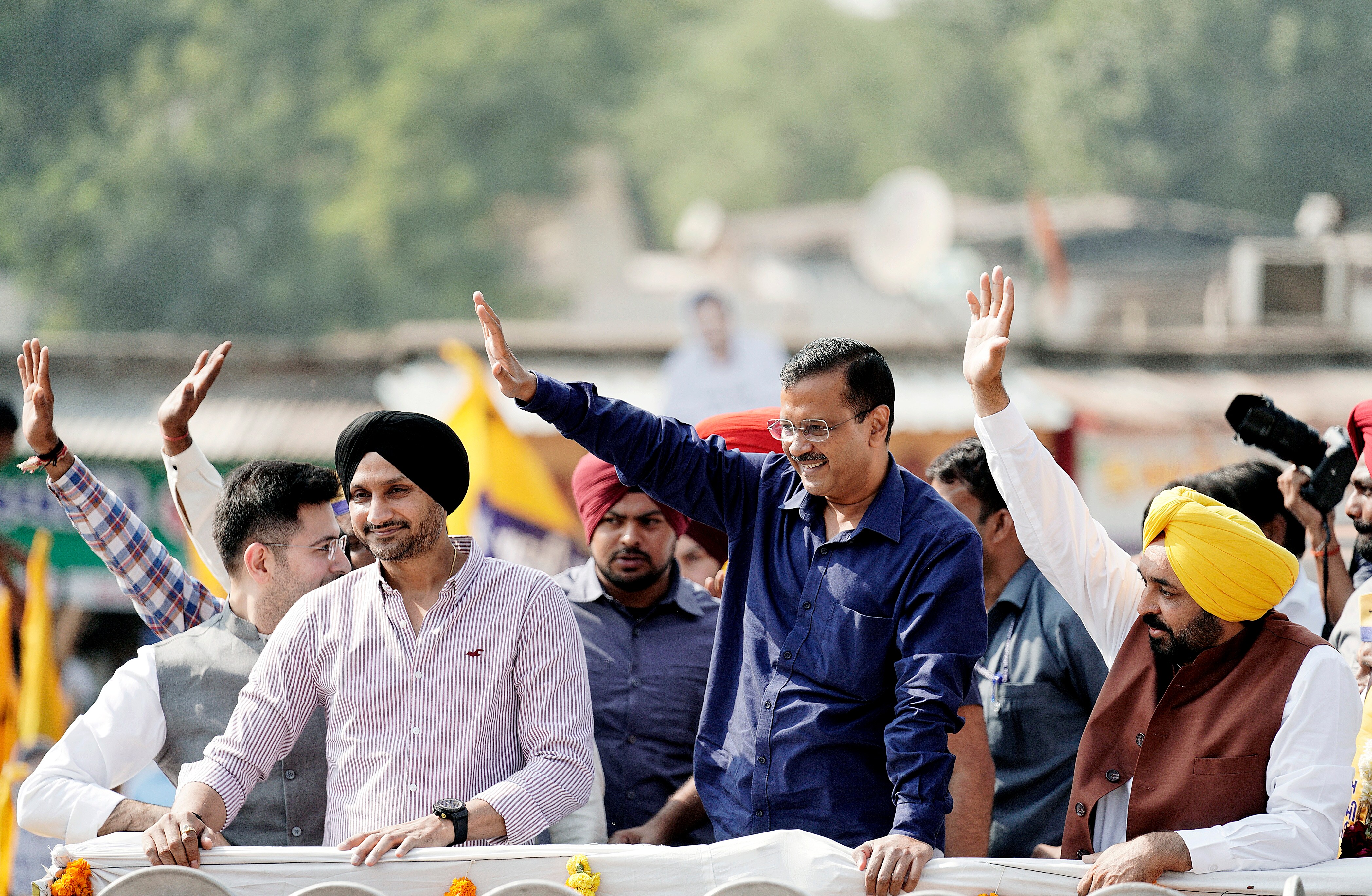Chief Minister of Delhi and AAP national convenor Arvind Kejriwal along with Punjab Chief Minister Bhagwant Mann and party leader Harbhajan Singh waves to supporters during a road show for the second phase of Gujarat Assembly Elections, in Ahmedabad on Thursday. (ANI Photo) Chief Minister of Delhi and AAP national convenor Arvind Kejriwal along with Punjab Chief Minister Bhagwant Mann and party leader Harbhajan Singh waves to supporters during a road show for the second phase of Gujarat Assembly Elections, in Ahmedabad on Thursday. (ANI Photo)