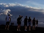 People stand on lava rock from a previous eruption near the Mauna Loa volcano as it erupts near Hilo, Hawaii. (AP Photo/Gregory Bull ) People stand on lava rock from a previous eruption near the Mauna Loa volcano as it erupts near Hilo, Hawaii. (AP Photo/Gregory Bull )