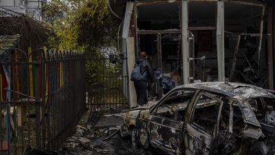 Russia-Ukraine War: Residents check the damage of a shop destroyed during a Russian attack in Kherson. (AP) Russia-Ukraine War: Residents check the damage of a shop destroyed during a Russian attack in Kherson. (AP)