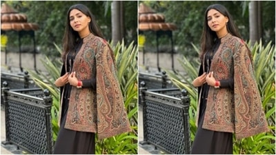Aishwarya embraced the upcoming winter season in a black dress and layered it with a multicoloureed coat with cut details at the sleeves. (Instagram/@aishu__)