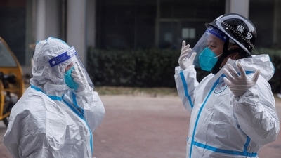 Pandemic prevention workers in protective suits get ready to enter an apartment building that went into lockdown as coronavirus disease (COVID-19) outbreaks continue in Beijing. (REUTERS file)