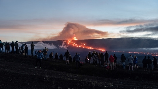 People gather to observe the eruption of the Mauna Loa Volcano in Hawaii, US. Hawaiians mark these traditions to honour, reflect as lava flows from Mauna Loa volcano (REUTERS/Go Nakamura)