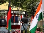Afghan policemen stand guard next to Indian and Afghan national flags, at a check point in Kabul, Afghanistan. 