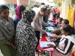 Polling agents look for the names of the people in a list as they come to cast their votes for the MCD elections, at a polling station in Khureji Khas, in East Delhi, Sunday, December 4, 2022. (PTI Photo/Manvender Vashist Lav) Polling agents look for the names of the people in a list as they come to cast their votes for the MCD elections, at a polling station in Khureji Khas, in East Delhi, Sunday, December 4, 2022. (PTI Photo/Manvender Vashist Lav)