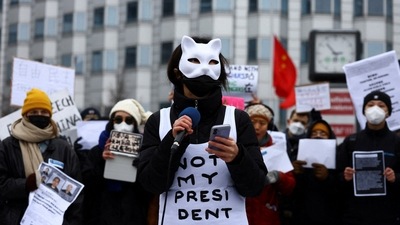 A demonstrator speaks as people hold placards during a protest against China's COVID-19 restrictions, in front of the Chinese Embassy, in Berlin, Germany, December 3. (REUTERS)