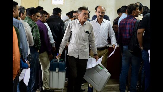 Polling official carry election related materials, and electronic voting Machine (EVM) as they leave from a dispatch centre a day ahead of the second phase of Gujarat state assembly elections in Ahmedabad. (AFP) Polling official carry election related materials, and electronic voting Machine (EVM) as they leave from a dispatch centre a day ahead of the second phase of Gujarat state assembly elections in Ahmedabad. (AFP)