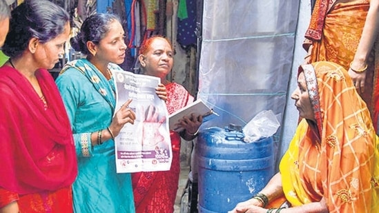 A health worker creates awareness about measles during a survey inside a slum following death of children due to the outbreak of the disease at Dharavi, in Mumbai, Saturday, December 3, 2022. (PTI Photo)