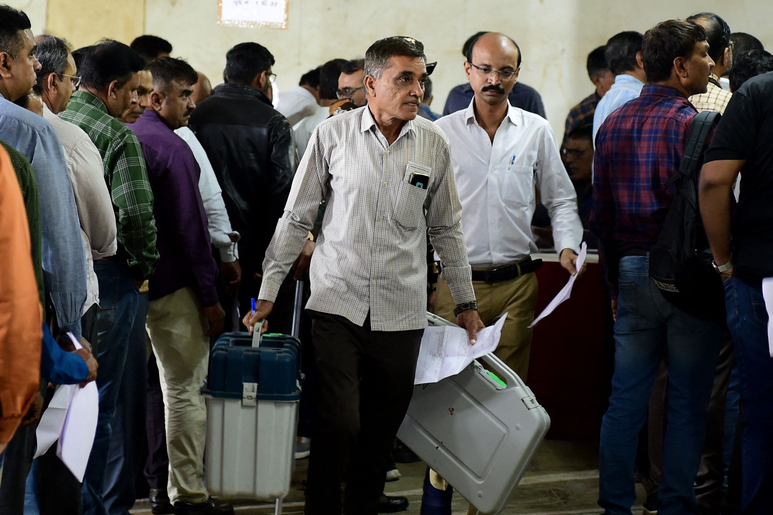 Polling official carry election related materials, and electronic voting Machine (EVM) as they leave from a dispatch centre a day ahead of the second phase of Gujarat state assembly elections in Ahmedabad. (AFP) Polling official carry election related materials, and electronic voting Machine (EVM) as they leave from a dispatch centre a day ahead of the second phase of Gujarat state assembly elections in Ahmedabad. (AFP)